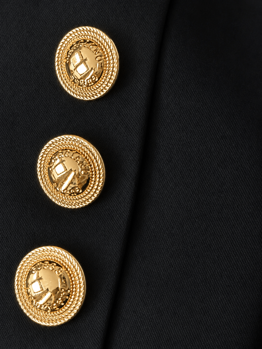 Detail van de goudkleurige knopen op een zwarte Marciano by Guess blazer met satijnglans.