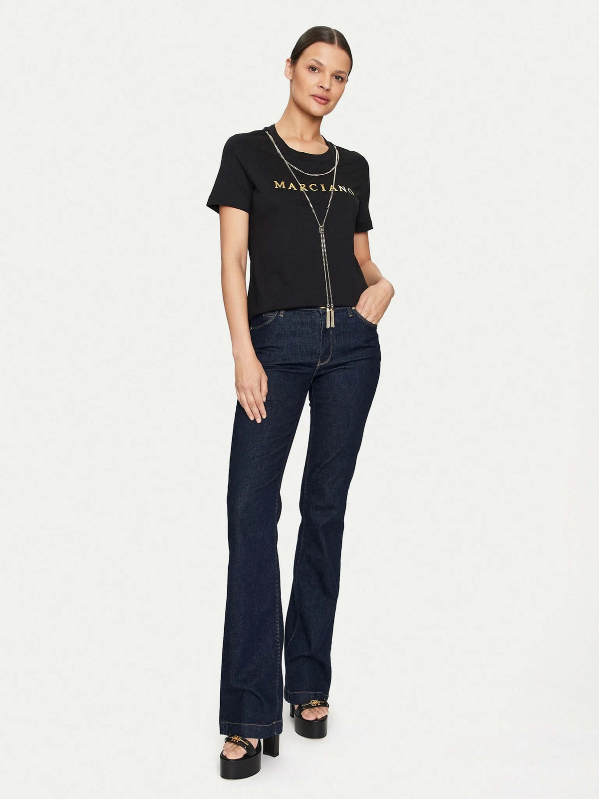 Zwart Marciano by Guess T-shirt met goudkleurig logo en ketting, gecombineerd met flared jeans.