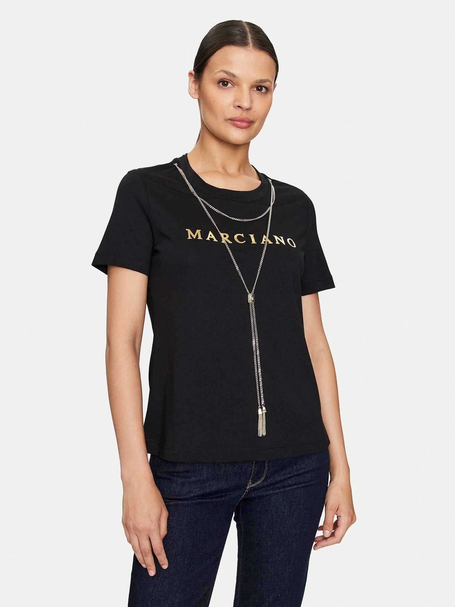 Model in een zwart Marciano by Guess logo-T-shirt met goudkleurige ketting.